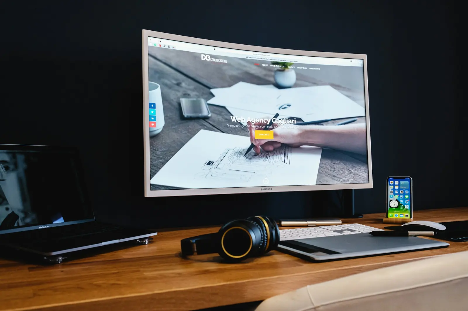 Designer's desk with a large monitor in a dark studio